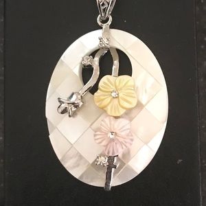 Pendant with floral design on long silver chain